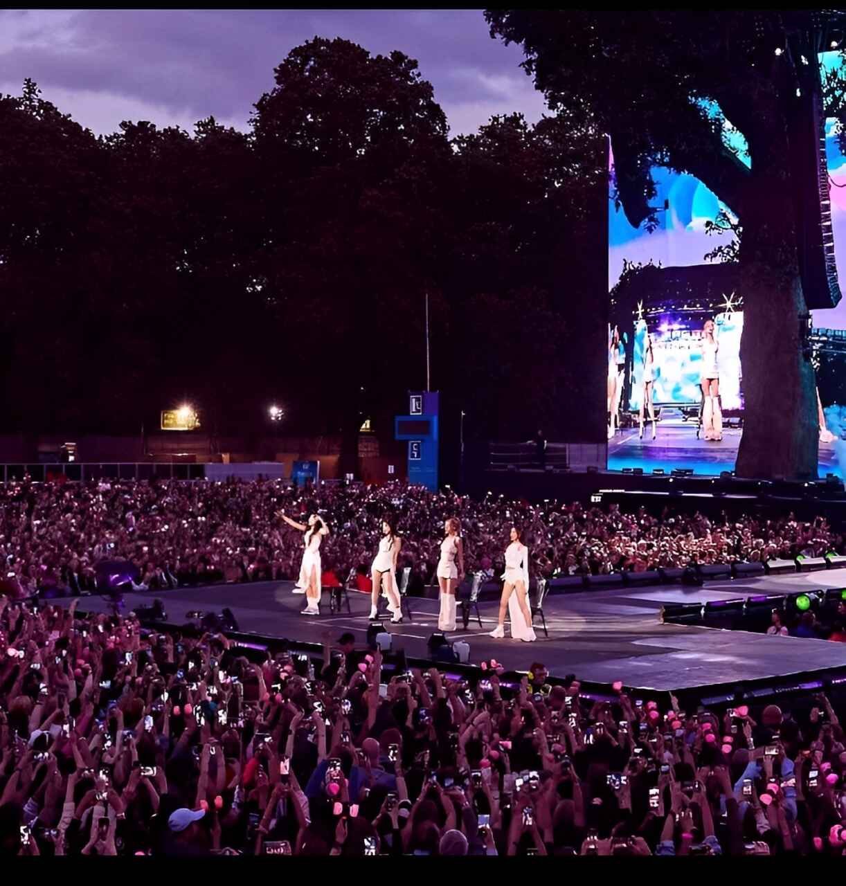  BLACKPINK performing on a grand stage in front of a huge crowd during a live concert.