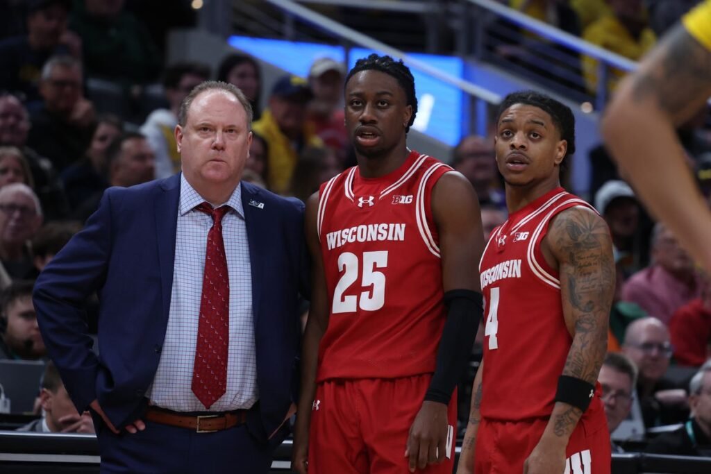 Big Ten coach strategizing with players during March Madness 2025.