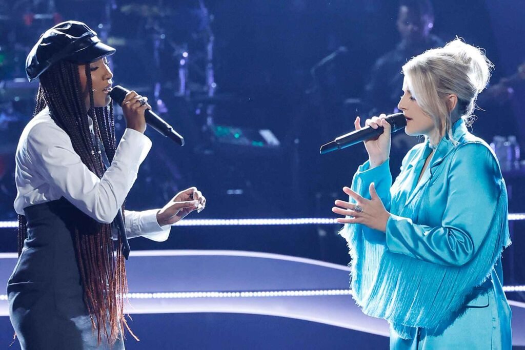 Two singers facing each other in an intense battle round on The Voice stage.