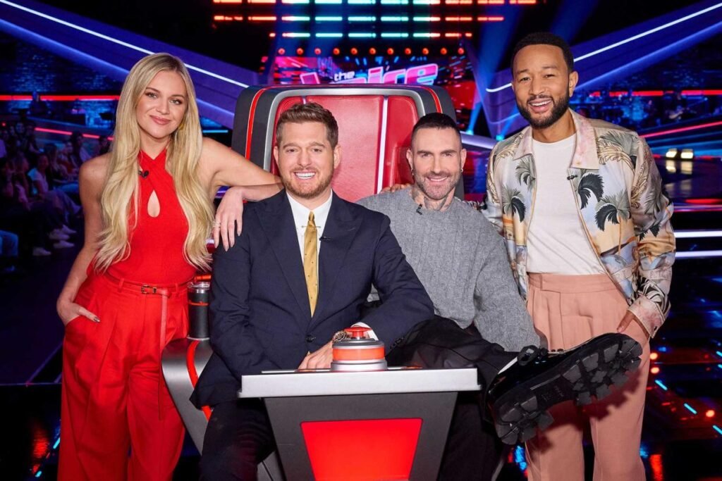 The Voice Season 27 coaches smiling and laughing together on set.