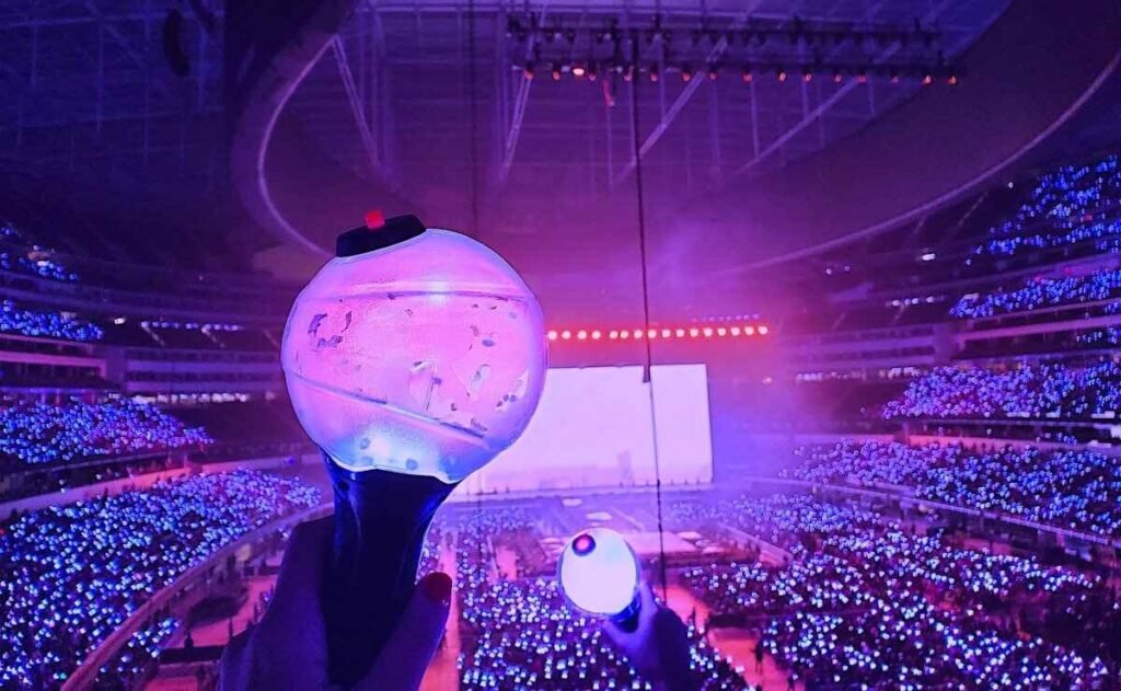 K-pop fans cheering with light sticks and banners