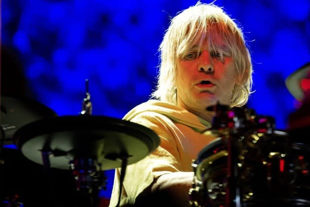 Zak Starkey behind his drum kit at the Royal Albert Hall, illuminated by stage lights.