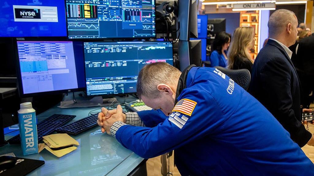Wall Street trader reacting to market crash amid U.S.-China tariff war.