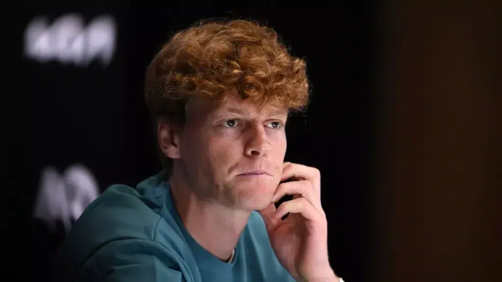 Jannik Sinner focused and deep in thought during an interview.