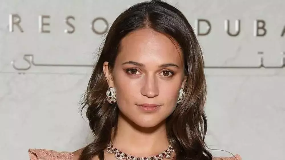 Alicia Vikander rehearsing lines or movement on a bare stage.