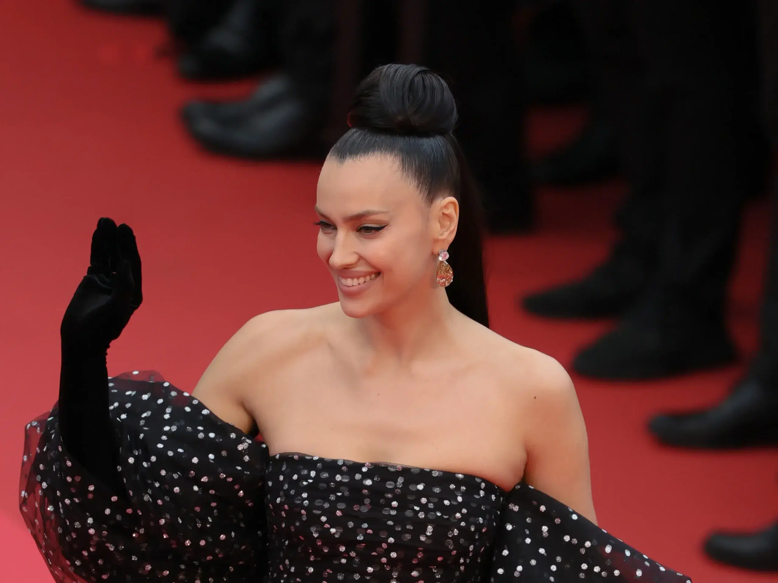 Irina Shayk in chiffon dress and sneakers on Cannes red carpet.