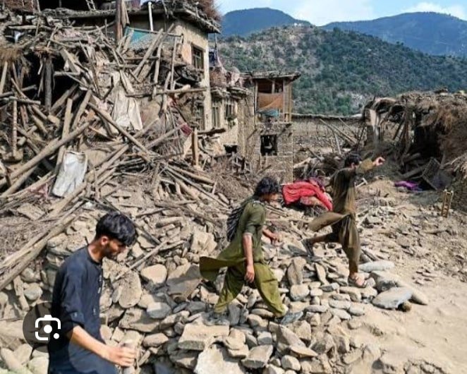  Civilian pick their way through a tangled pile of stones, wooden beams, and collapsed mud‑brick homes in a mountainous region of northern Afghanistan, following a major earthquake.